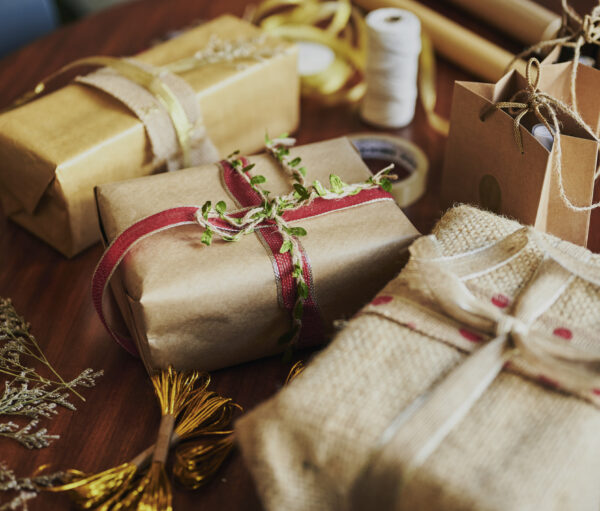 Variety of Christmas presents and in environmentally friendly wrapping paper sitting on a table during the holidays